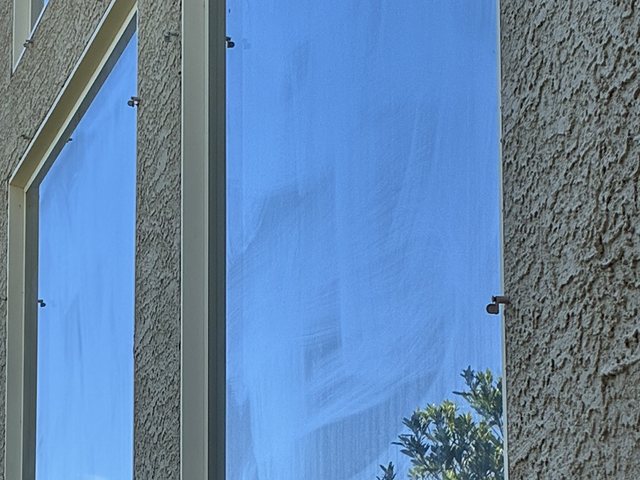 Tall window with streaky glass before cleaning